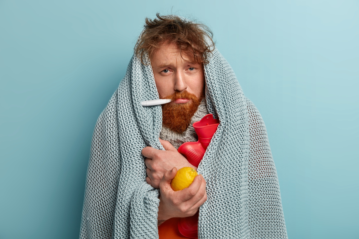 peptides for immunity man measures body temperature under a blanket